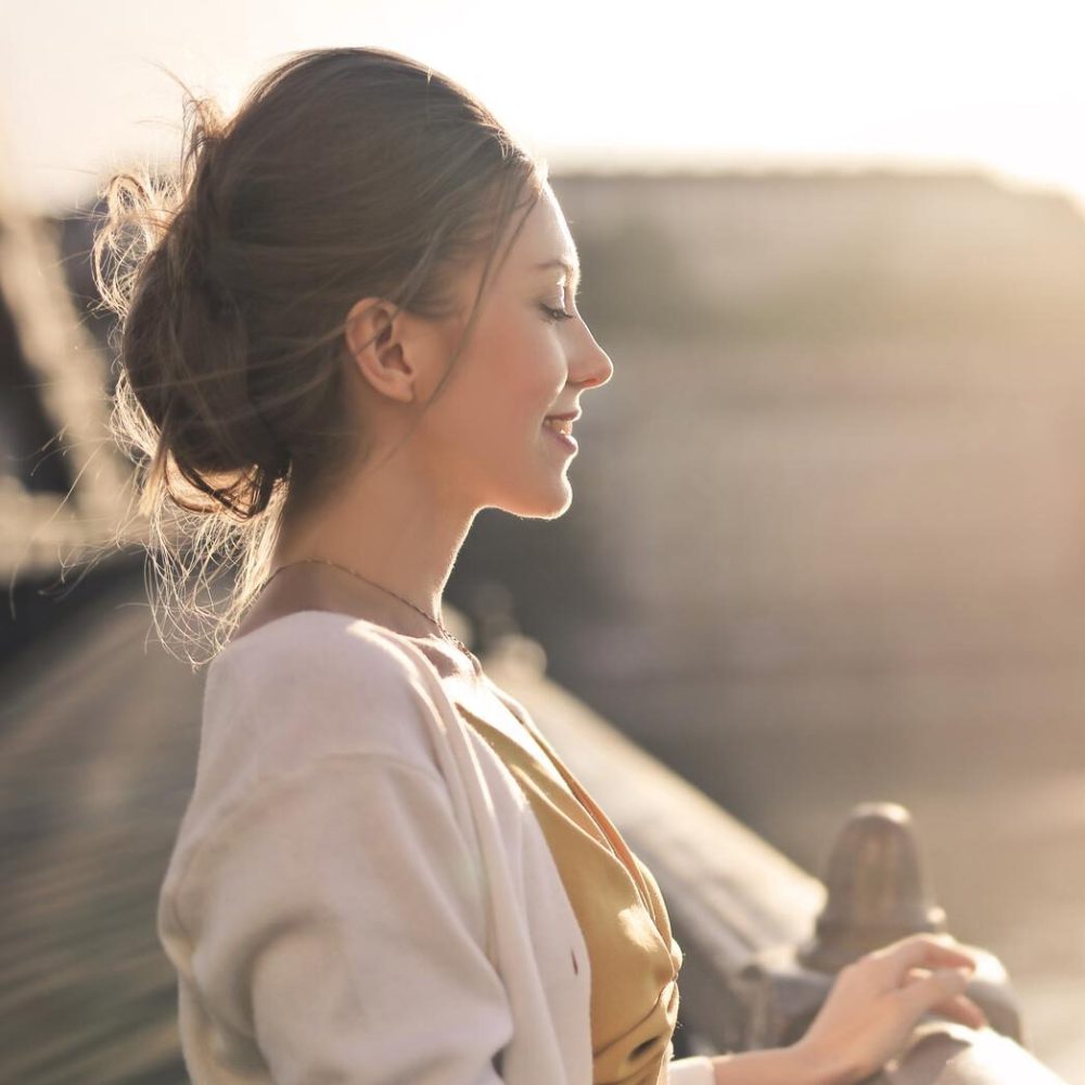 young-woman-on-a-bridge-in-front-of-a-sunset